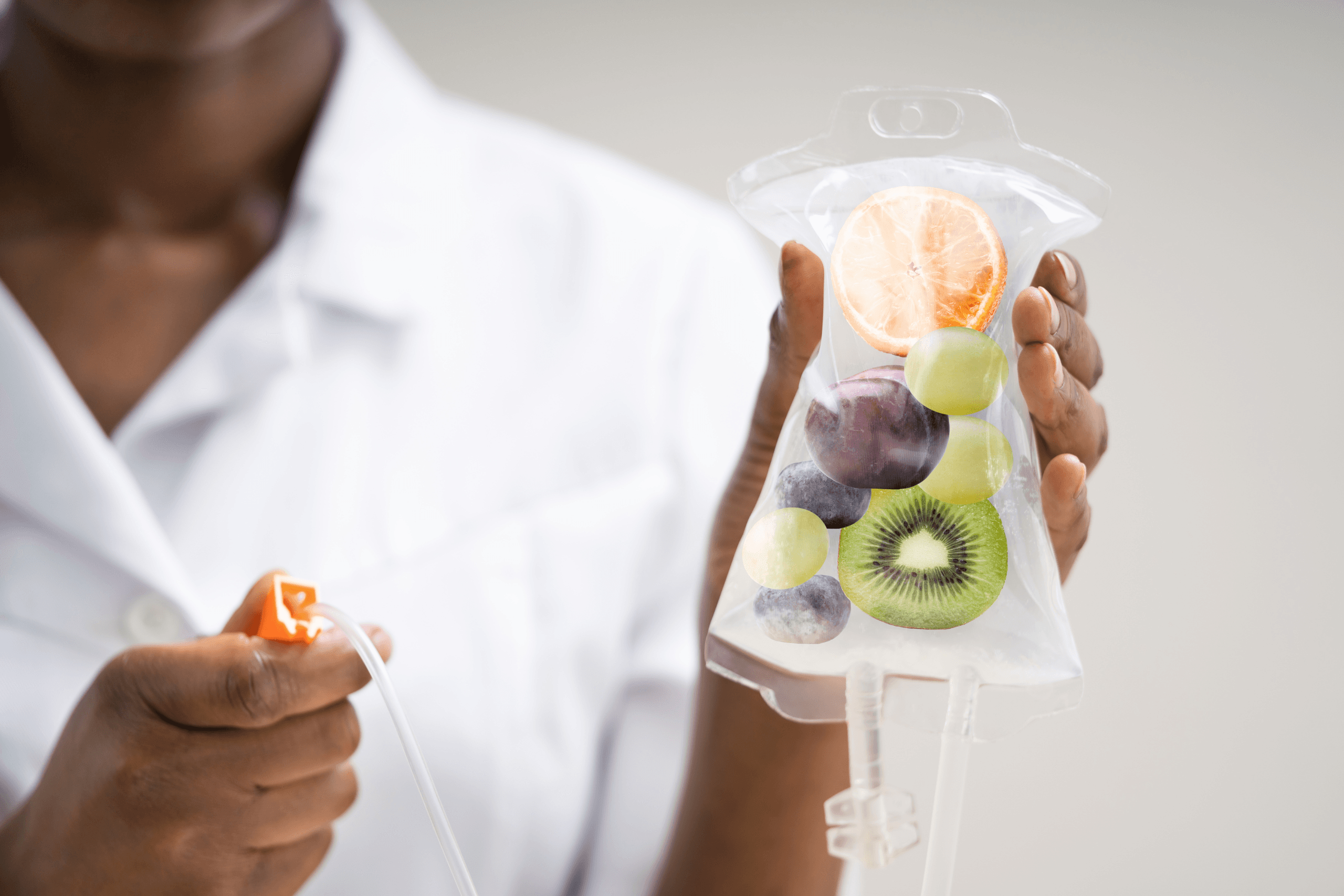 A practitioner holding an intravenous drip bag containing fresh fruit